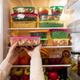 Woman placing leftovers into fridge full of food